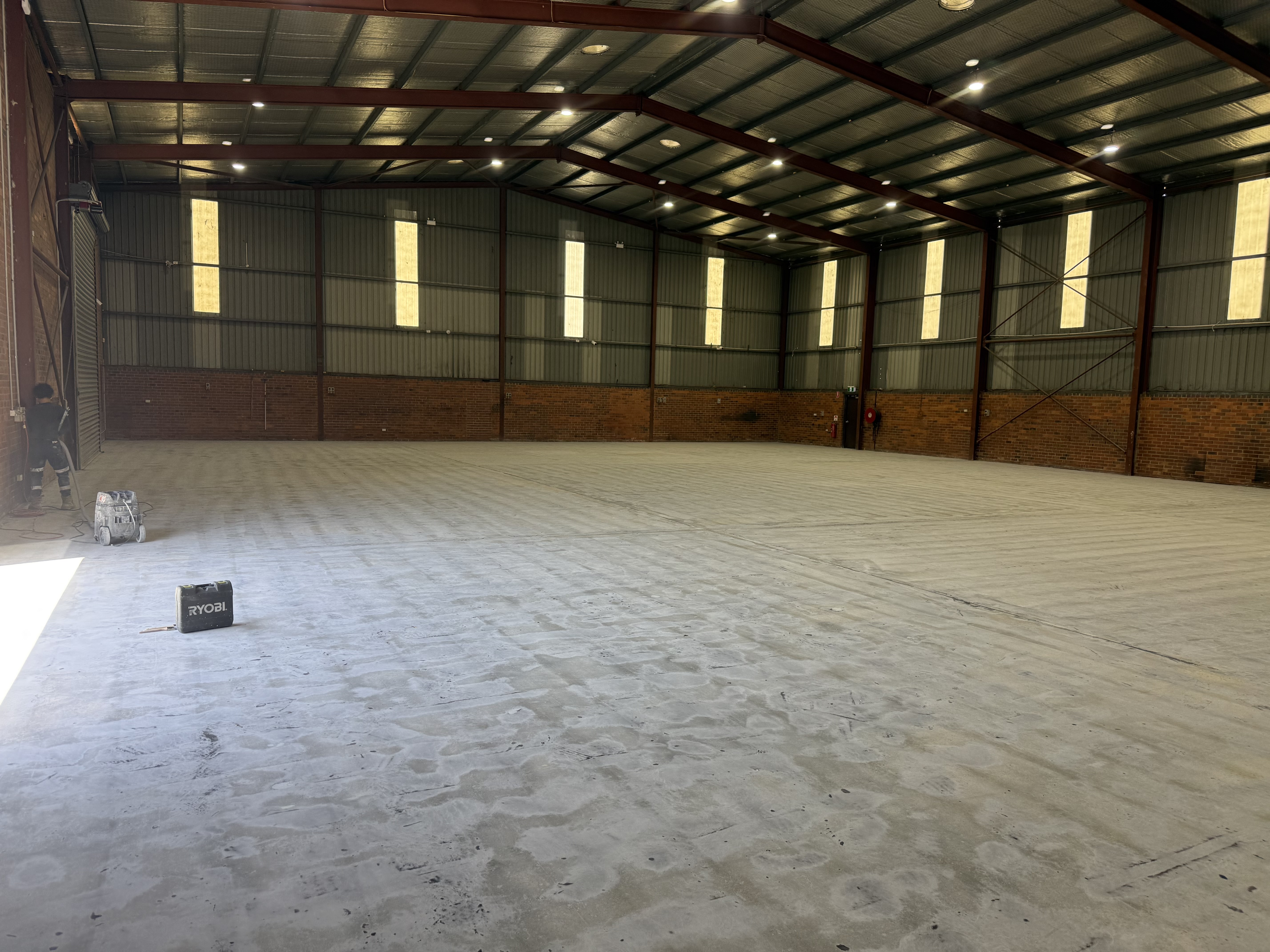 Specialist Contracting Services crew applying concrete surface preparation in a warehouse