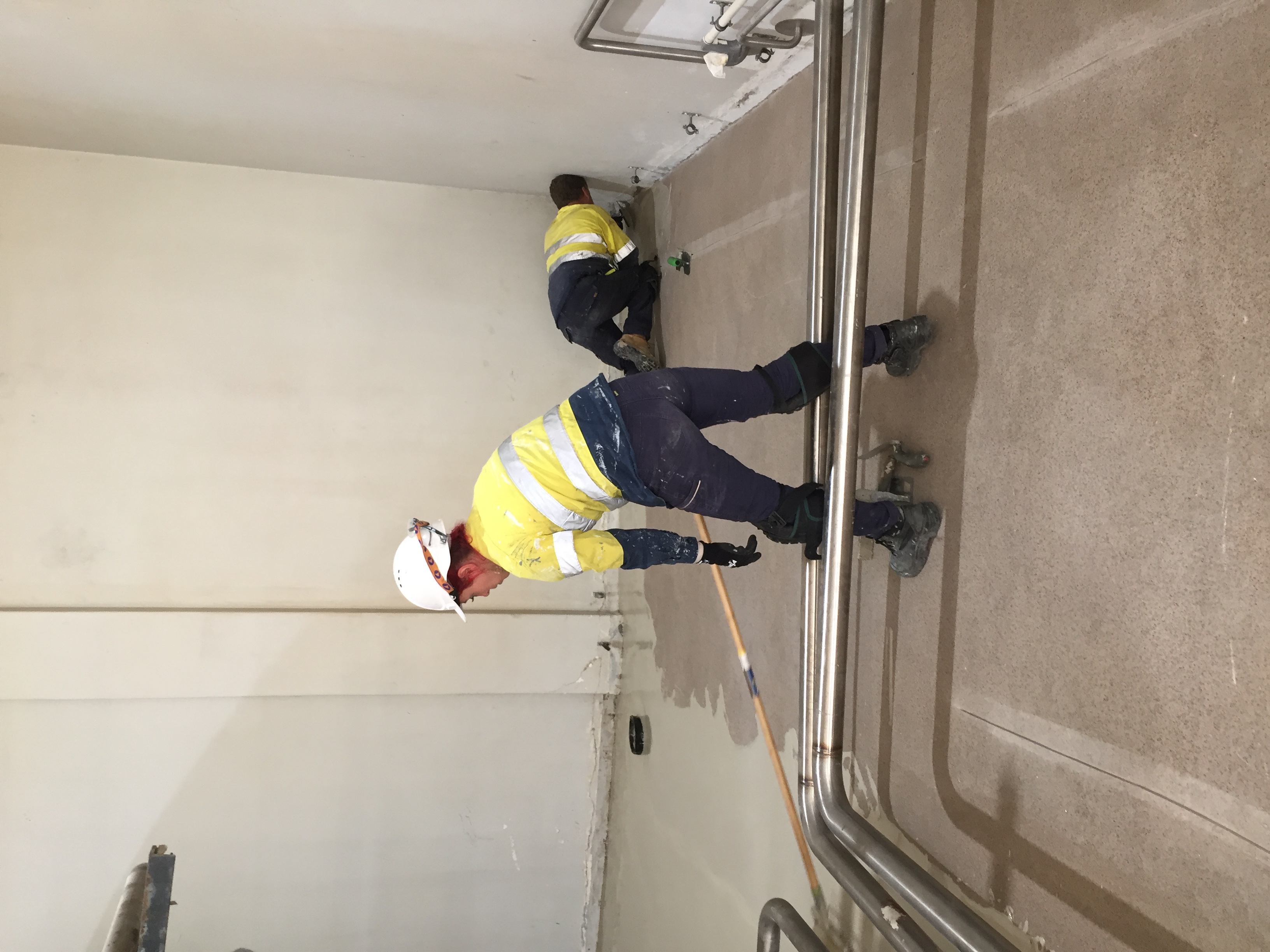 Blue epoxy safety walkway with black borders and yellow hazard ramp markings installed in an industrial facility by Specialist Contracting Services